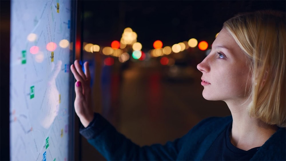 İnsan, gece vakti dışarıda akıllı telefon ekranında harita ve navigasyon uygulaması kullanıyor.