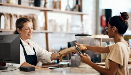 Kahve dükkanında müşteri ile satıcı arasında el sıkışma, dostane iletişim ve satış tamamlanması, mutlu müşteri ve satış ortamı, samimi ve profesyonel hizmet sağlanıyor.