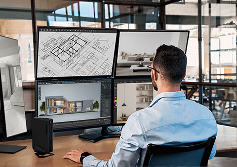 Yüksek performanslı dizüstü bilgisayar ve tasarım yazılımı kullanırken ofiste çalışan kişi, çok ekranlı ve profesyonel tasarım ortamında çalışıyor.