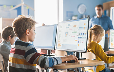 Çocukların bilgisayar kullanırken ders çalıştığı modern sınıf ortamı, eğitim teknolojileri ve eğitim için uygun dizüstü bilgisayarlar.