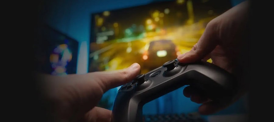 Oyun ve bilgisayar teknolojileri ile profesyonel oyun deneyimi için dizüstü bilgisayar ve oyun joysticki kullanımı.