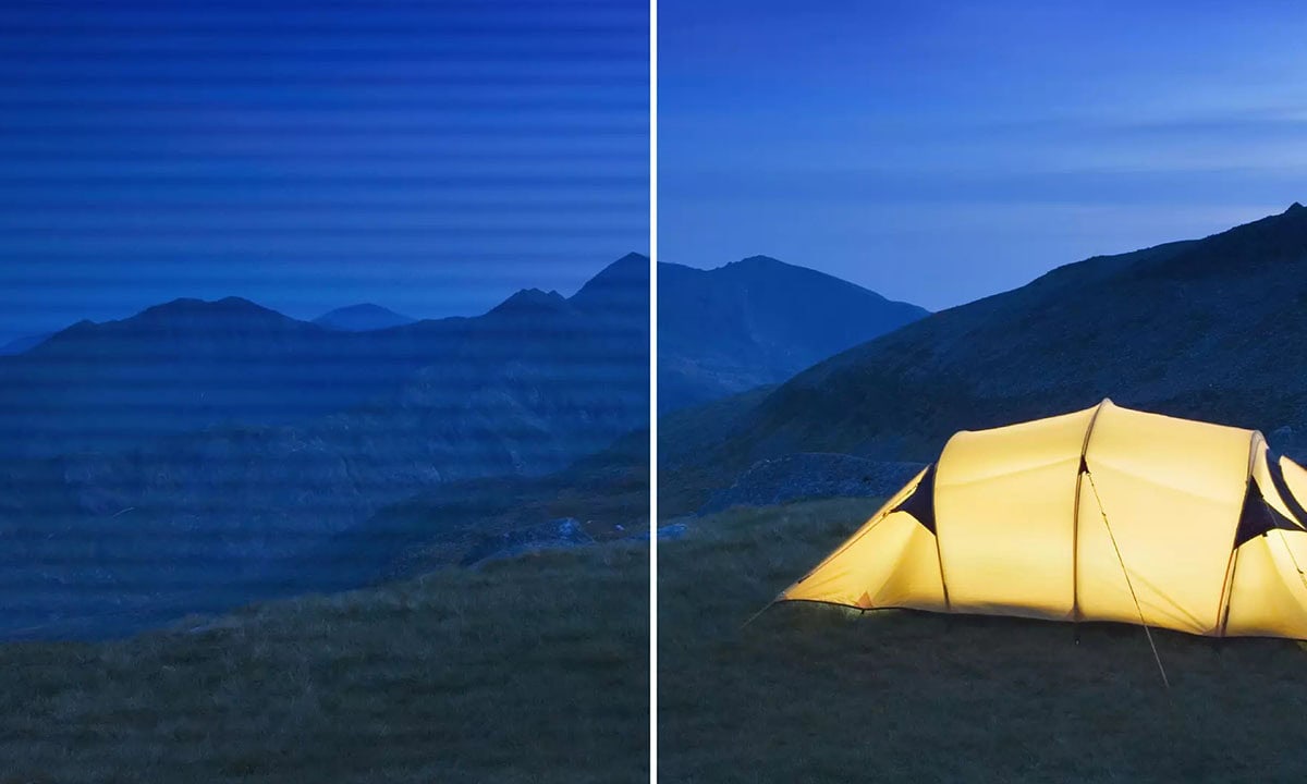 Yüksek çözünürlüklü görüntüde, gece manzarasında dağlar ve yıldızlı gökyüzü ile aydınlatılmış kamp çadırı yer alıyor. Doğa ve açık hava aktiviteleri ile ilgili içeriklerde kullanılmak üzere ideal.