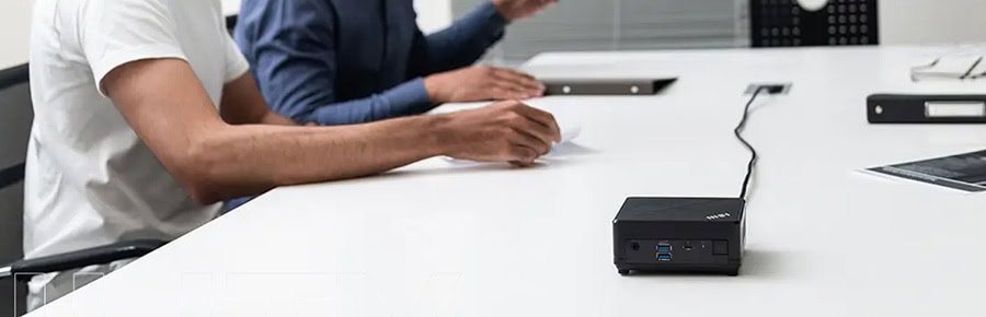 İki kişi, toplantı masasında dizüstü bilgisayar ve bağlantı noktası kullanıyor, modern ofis ortamında yüksek performanslı teknolojik ekipmanlar.
