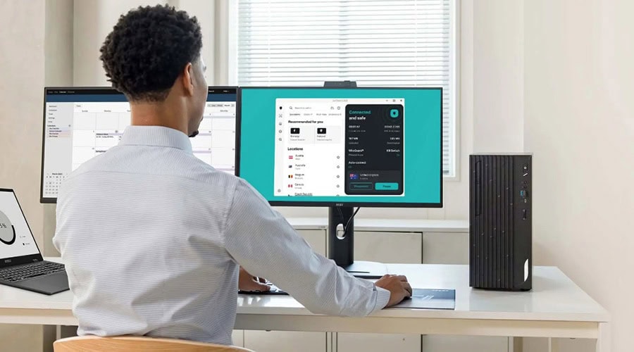 Yazılım geliştirici, bilgisayar ekranında kod ve uygulama arayüzleriyle çalışıyor. Modern çalışma ortamında dizüstü bilgisayar ve monitörler kullanılıyor.